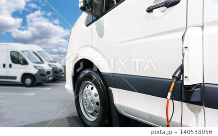 Close up of electric delivery van with connected charging cable Close up of electric delivery van with connected charging cable 140538056