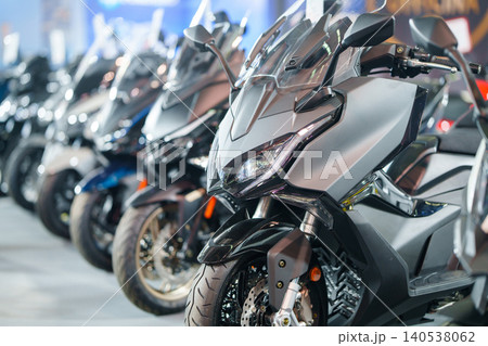 Row of new motor scooters in a modern dealership showroom Row of new motor scooters in a modern dealership showroom 140538062