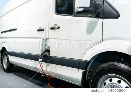 Close up of electric delivery van with connected charging cable Close up of electric delivery van with connected charging cable 140538064