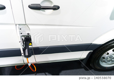 Close up of electric delivery van with connected charging cable Close up of electric delivery van with connected charging cable 140538070
