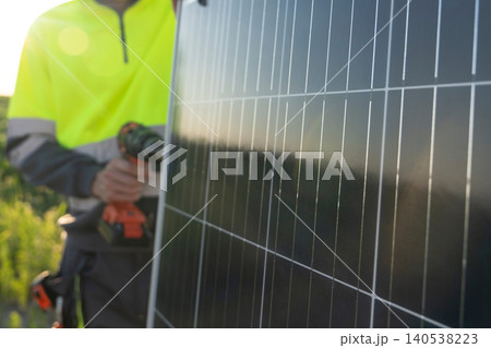 A worker installs a solar panel. 140538223