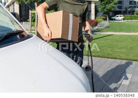 Driver with charging plug next to of electric van. Driver with charging plug next to of electric van. 140538348
