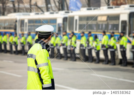 Policemans one the street. Many policemens in the background, one in foreground. Policemans one the street. Many policemens in the background, one in foreground. 140538362
