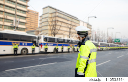 Policemans one the street. Many policemens in the background, one in foreground. 140538364