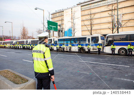 Policemans one the street. Many policemens in the background, one in foreground. 140538443