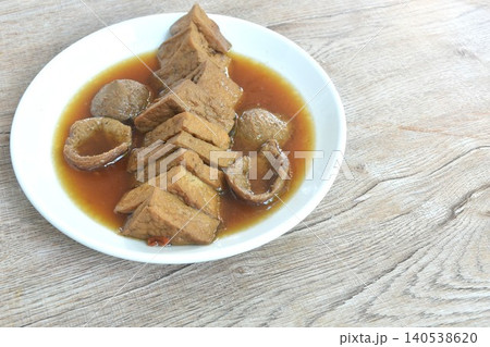 boiled slice triangle tofu and gluten in black herb soup vegetarian food on plate boiled slice triangle tofu and gluten in black herb soup vegetarian food on plate 140538620