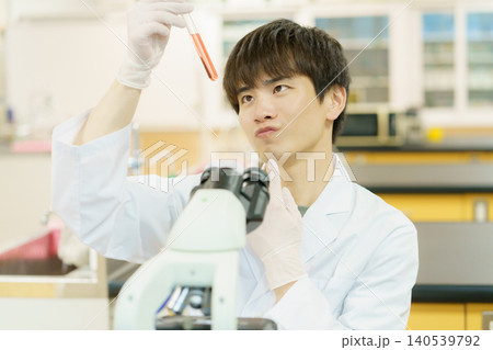 顕微鏡で作業をする白衣を着た若い日本人男性 実験 研究 開発 勉強 顕微鏡で作業をする白衣を着た若い日本人男性 実験 研究 開発 勉強 140539792