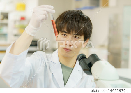 顕微鏡で作業をする白衣を着た若い日本人男性 実験 研究 開発 勉強 顕微鏡で作業をする白衣を着た若い日本人男性 実験 研究 開発 勉強 140539794