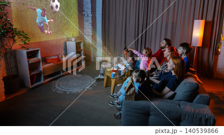 Family watching soccer projection at home with excited children and match night atmosphere. 140539866