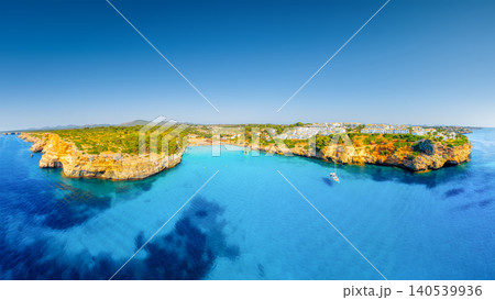 Aerial view of scenic Mallorca beach and azure bay with yacht in Spain. Aerial view of scenic Mallorca beach and azure bay with yacht in Spain. 140539936