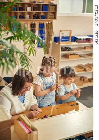 Quiet group activity with preschool children exploring tiny colorful objects. Quiet group activity with preschool children exploring tiny colorful objects. 140540213