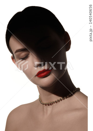 Close beauty portrait of woman with red lips and soft shadow over closed eyes on white background. 140540656
