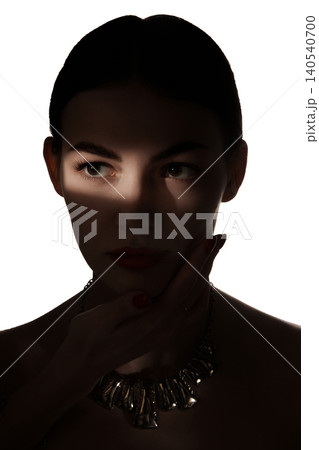 Close beauty portrait of serious woman with eye shadow strip and dark jewelry. Close beauty portrait of serious woman with eye shadow strip and dark jewelry. 140540700
