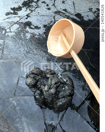 神社の手水舎で清めの水を注ぐ柄杓と石造りの龍神像 神社の手水舎で清めの水を注ぐ柄杓と石造りの龍神像 140541626