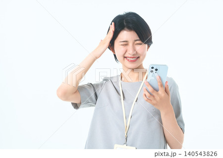 スマホを見てうっかりした表情で頭に手を当てる若い女性 140543826