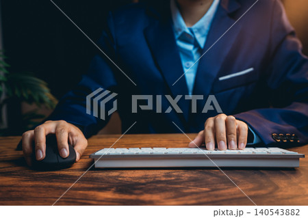 Professional Business Person Working at Desk with Keyboard and Mouse in Office Setting Professional Business Person Working at Desk with Keyboard and Mouse in Office Setting 140543882