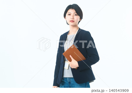 バインダーを抱えて正面を向く落ち着いたビジネス女性 140543909