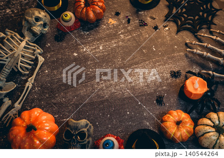 Halloween flat lay. Spooky Halloween Decorations with Skeleton, Pumpkins, Candles, and Creepy Props on Wooden Tabletop Halloween flat lay. Spooky Halloween Decorations with Skeleton, Pumpkins, Candles, and Creepy Props on Wooden Tabletop 140544264