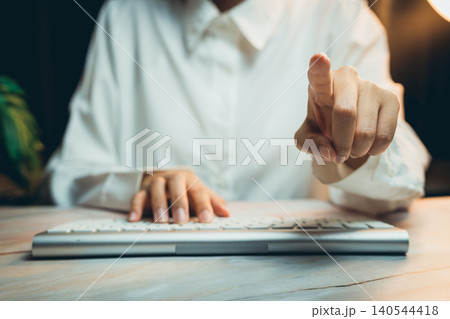 Business concept of working. Focused Businesswoman Using Computer Keyboard with Gesture in Modern Office Environment at Night 140544418