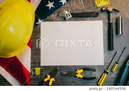 Engineer background. Tools and Equipment Arranged on Workspace with Blank Paper and American Flag for Construction and DIY Projects Engineer background. Tools and Equipment Arranged on Workspace with Blank Paper and American Flag for Construction and DIY Projects 140544506
