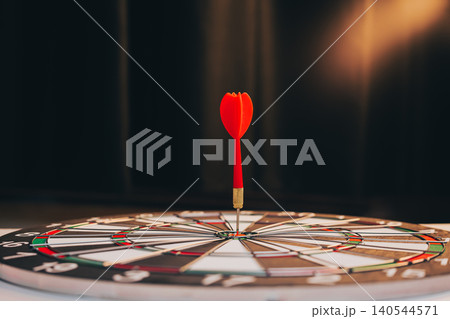 Business Target concept. Red Dart Sticking at the Center of Dartboard Signifying Precision and Focus in Target Practice 140544571