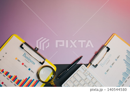 Flat lay of Business Analysis Tools with Charts and Magnifying Glass on a Vibrant Background for Professional Use 140544580