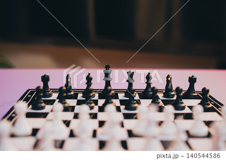 Chess Game. Chessboard with Black and White Pieces Ready for Game on a Stylish Surface in Soft Focus Background Chess Game. Chessboard with Black and White Pieces Ready for Game on a Stylish Surface in Soft Focus Background 140544586