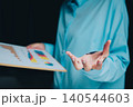 Business professional presenting data sheet with colorful graphs and charts during a corporate meeting session 140544603