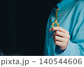 Success key concept. Elegant Gold Key Held by Hand in Soft Focus Setting with Dark Background, Symbolizing Unlocking Opportunities 140544606