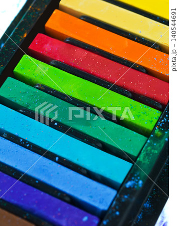 Paint, pastel and color chalk in studio for rainbow or vibrant creativity, texture and pigments for fine or visual arts. Oil or watercolor sticks, set or palette to shade or blend with composition. 140544691