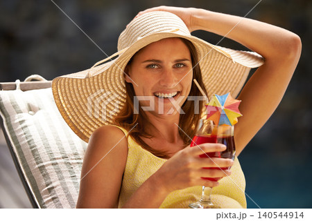 Woman, cocktail and drink by swimming pool on lounge chair for summer, holiday and tropical vacation. Young person or tourist in portrait by hotel with hat, glass or alcohol for happy, outdoor break Woman, cocktail and drink by swimming pool on lounge chair for summer, holiday and tropical vacation. Young person or tourist in portrait by hotel with hat, glass or alcohol for happy, outdoor break 140544914