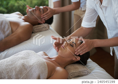 Holiday, head massage and couple relax in spa for care of body with rest on table of retreat for honeymoon. Hotel, man and woman together in resort for health, wellness and luxury for skincare 140545199