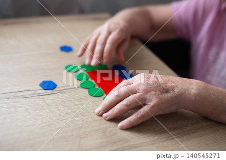 Senior hands playing cognitive game for memory health Senior hands playing cognitive game for memory health 140545271