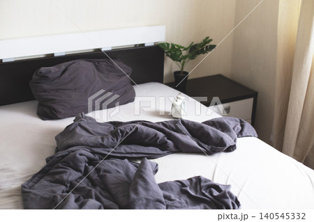 Unmade bed in modern bedroom, morning wake-up Unmade bed in modern bedroom, morning wake-up 140545332