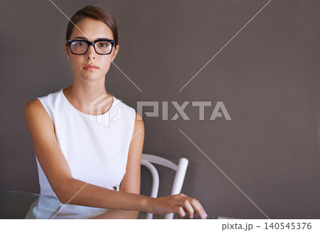 Model, serious and portrait in glasses in studio, vision and trendy frame eyewear for optometry. Consultant, french woman and face in spectacles with pride or prescription eyecare by brown background Model, serious and portrait in glasses in studio, vision and trendy frame eyewear for optometry. Consultant, french woman and face in spectacles with pride or prescription eyecare by brown background 140545376