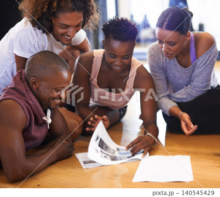 Dancer, talking and group on floor with people reading paper, catalog or review of dancing. Students, learning and conversation in studio of academy with article on ground with happy discussion 140545429