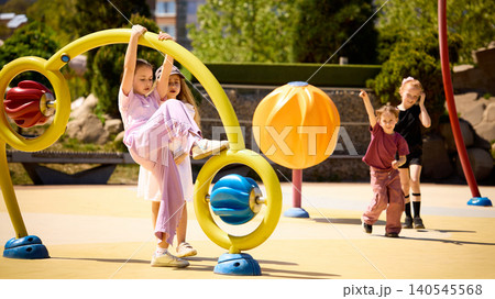 Children playing on colorful outdoor playground equipment in sunny park. Children playing on colorful outdoor playground equipment in sunny park. 140545568