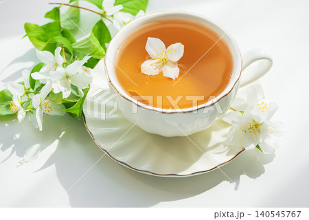 Jasmine tea in white teacup with fresh flowers Jasmine tea in white teacup with fresh flowers 140545767