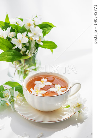 Jasmine tea cup with fresh flowers representing relaxation Jasmine tea cup with fresh flowers representing relaxation 140545771