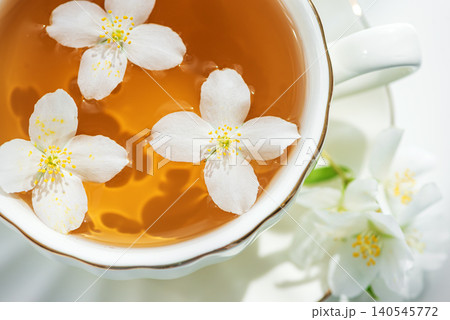 Jasmine flowers floating in fragrant herbal tea cup Jasmine flowers floating in fragrant herbal tea cup 140545772