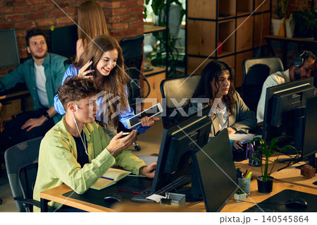 Office colleagues collaborating around computer workstation. 140545864