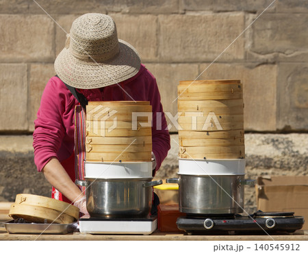Vendor cooking Asian street food in bamboo steamers at Prague Karlin Vendor cooking Asian street food in bamboo steamers at Prague Karlin 140545912