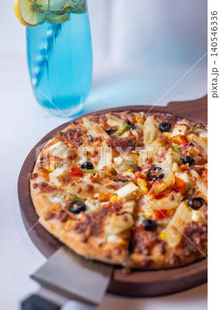 pizza with a glass of water, olives, ham and cheese 140546336