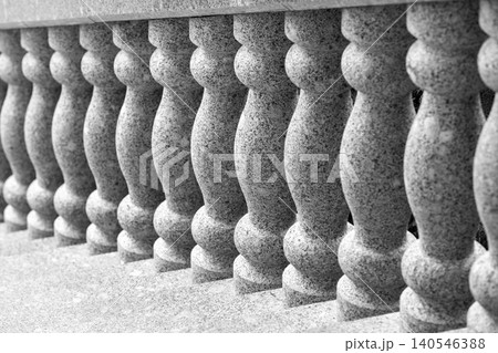 Elegant stone balustrade featuring repeating turned granite columns Elegant stone balustrade featuring repeating turned granite columns 140546388
