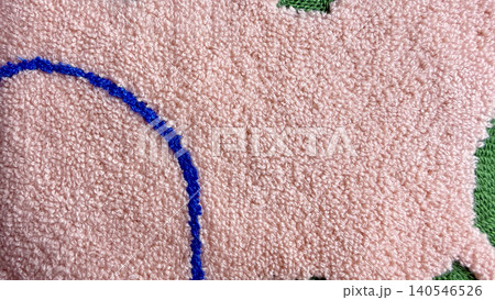 plush pink tufted rug closeup reveals soft fluffy texture and bold blue curved design with green tufts plush pink tufted rug closeup reveals soft fluffy texture and bold blue curved design with green tufts 140546526