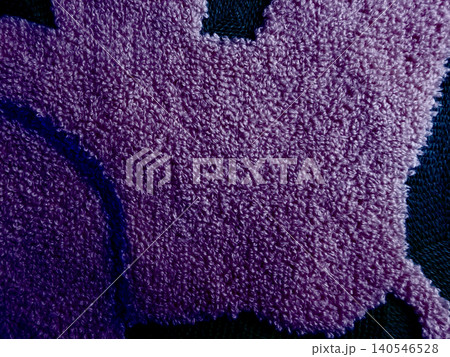 purple shaggy rug with plush fluffy texture in intimate macro detail against dark navy background 140546528