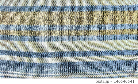 cozy detailed horizontal striped knit fabric closeup in soothing blue beige cream hues with ribbed hem texture 140546541