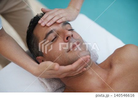 Hotel, spa and man relax for facial massage on table in resort, calm and care for body in vacation. Holiday, luxury and male person on break for weekend and lodge with treatment for skincare Hotel, spa and man relax for facial massage on table in resort, calm and care for body in vacation. Holiday, luxury and male person on break for weekend and lodge with treatment for skincare 140546616