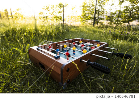Foosball table in tall grass in a garden, reflecting everyday recreation as a prelude to the upcoming global soccer championship 140546781