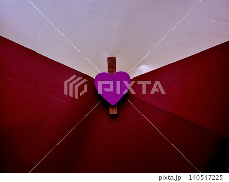 vibrant purple heart wooden clothespin secures romantic red envelope with tender intimacy 140547225